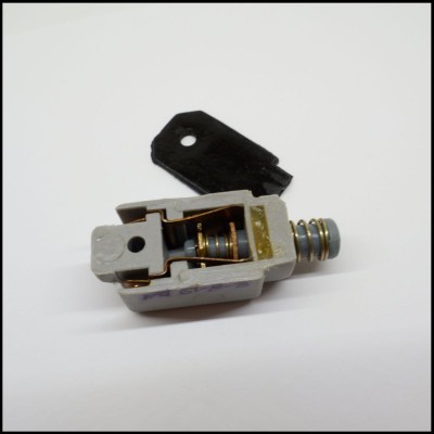 Dispositivo mecânico com mola, parafuso e peça preta em fundo branco