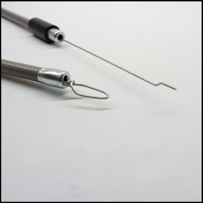 Duas hastes metálicas finas com pontas distintas, uma com ângulo recto e outra em laço, em fundo branco