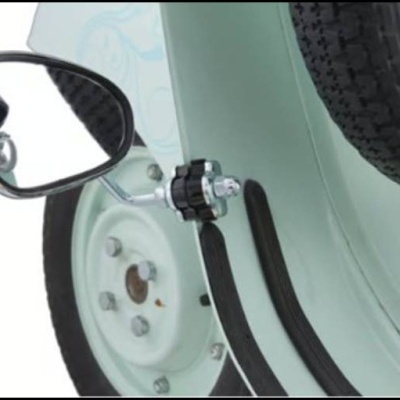 Retrovisor lateral cromado numa mota verde água com roda de metal e pneu preto