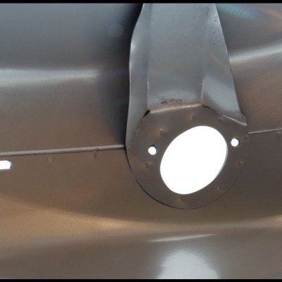 Hélice metálica de avião prateada com marcas de uso.