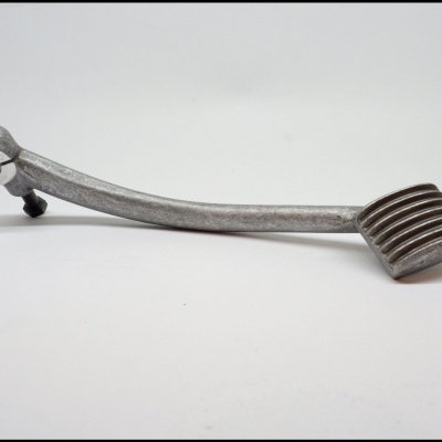 Pedal metálico prateado para veículo sobre fundo branco