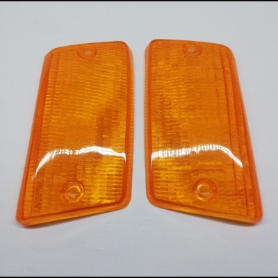 Par de lentes laranja para farolim dianteiro com textura quadriculada.