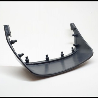 Peça plástica preta curva com pinos salientes sobre fundo branco