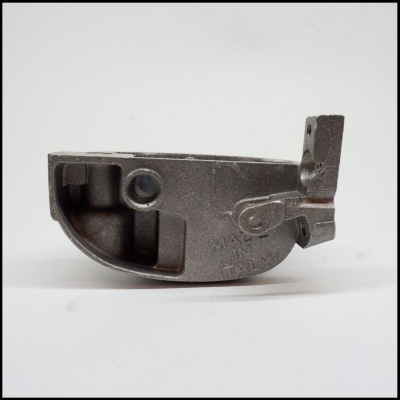 Peça metálica cinzenta com inscrições MADE IN ITALY e números em fundo branco