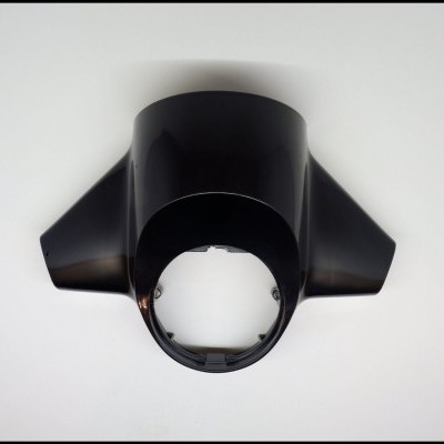 Peça preta em plástico com formato côncavo e duas extensões laterais sobre fundo branco