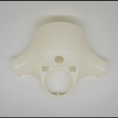 Peça plástica creme com orifícios circulares sobre fundo branco