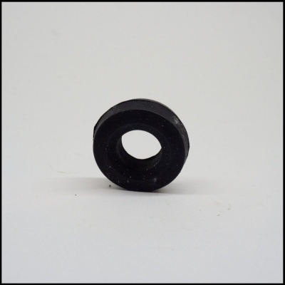Peça redonda preta com furo central sobre superfície branca