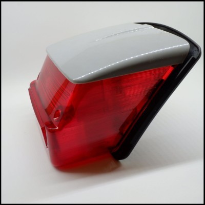 Luz traseira automóvel vermelha com estrutura branca e moldura preta