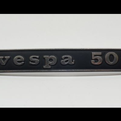 Emblema metálico preto com relevo cinzento vespa 50s