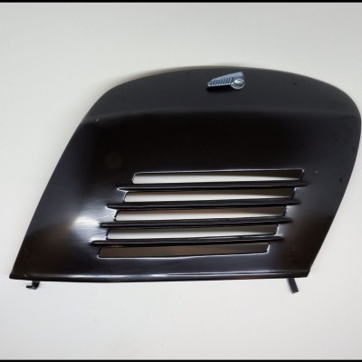 Grelha de carro preta com aberturas horizontais e pequeno emblema cromado