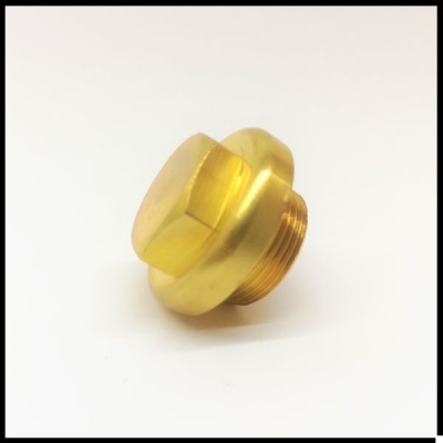 Peça metálica dourada com uma extremidade hexagonal e roscas