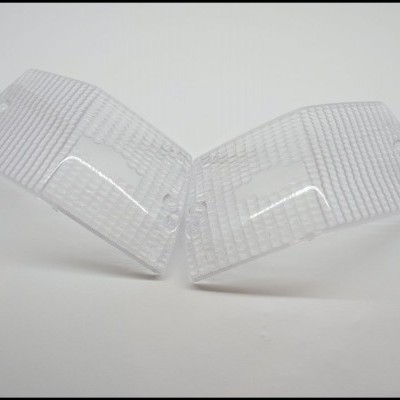 Duas tampas transparentes de plástico com padrão de linhas em fundo branco