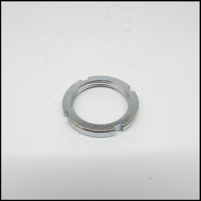 Anel metálico prateado com ranhuras em superfície branca