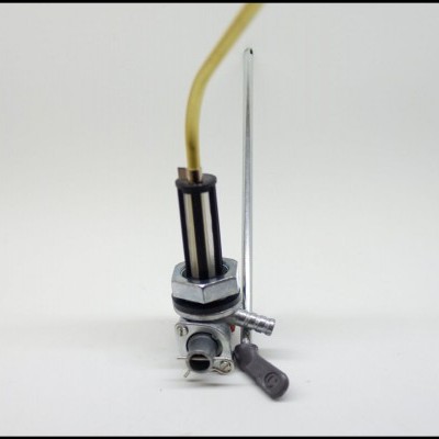 Válvula metálica prateada com tubo amarelo e alavanca preta sobre fundo branco