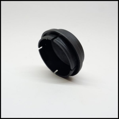 Peça redonda preta de plástico com bordas curvas e aberturas em fundo branco