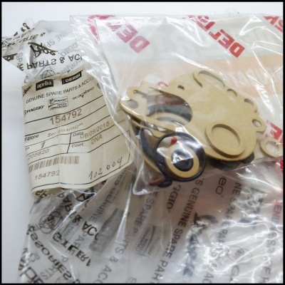 Peças sobressalentes para veículos Piaggio em embalagens plásticas transparentes com etiquetas visíveis.