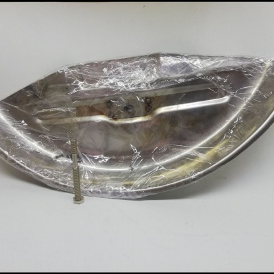 Peça metálica prateada refletiva coberta por plástico transparente