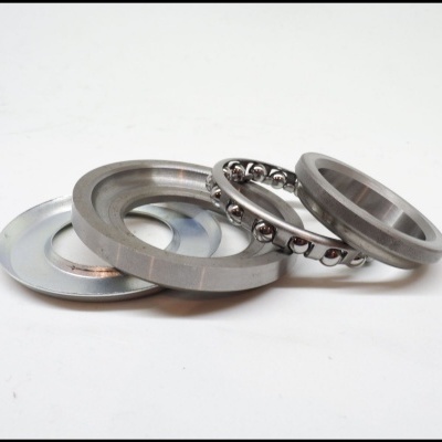 Peças metálicas incluindo anéis e rolamento esférico prateados sobre fundo branco