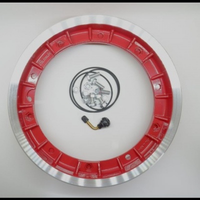 Anel metálico grande prateado com interior vermelho e peças pequenas no centro