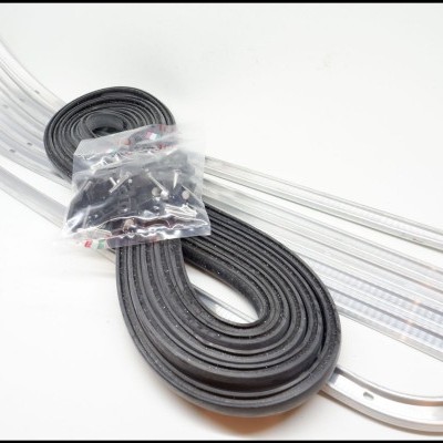 Tiras flexíveis transparentes, fita preta enrolada e saco com parafusos sobre superfície branca