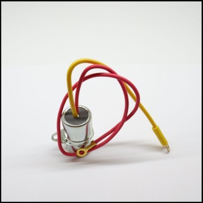 Componente eletrónico cilíndrico metálico com fios amarelo e vermelho num fundo branco.