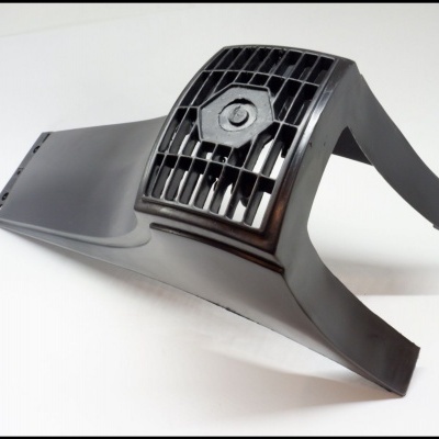 Peça de plástico preta com grelha quadrada e parafuso central sobre fundo branco