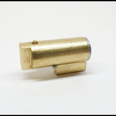 Objeto metálico dourado cilíndrico com base retangular