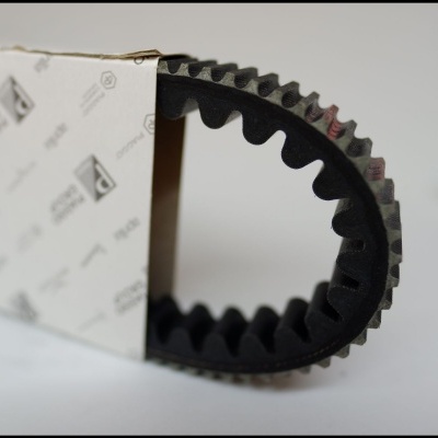 Correia dentada preta parcialmente dentro de caixa branca com padrões de logótipos