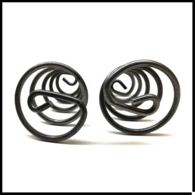 Brincos redondos em espiral de metal preto sobre fundo branco