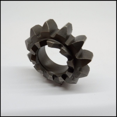 Engrenagem metálica cinza escuro com dentes largos sobre superfície branca