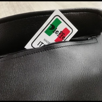 Produto em couro preto com etiqueta Made in Italy