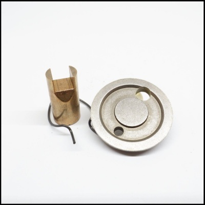 Peças metálicas e mola sobre fundo branco.