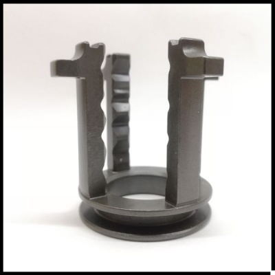 Peça metálica preta com base circular e três braços verticais irregulares