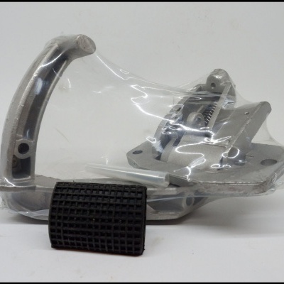 Peça metálica cinzenta com tubulação e peça preta quadriculada embalada em plástico