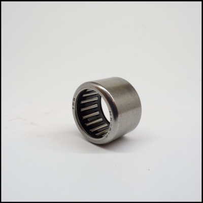 Rolamento de agulhas metálico prateado sobre superfície branca