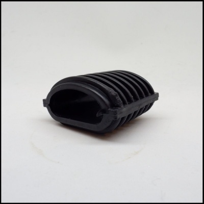 Peça preta de borracha ou plástico com ranhuras, sobre fundo branco