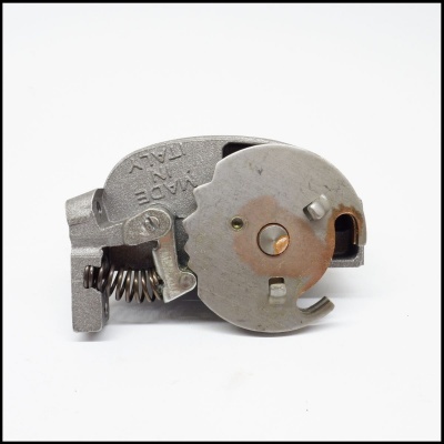 Peça metálica mecânica cinza com mola e texto MADE IN ITALY