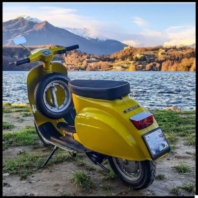 Motociclo amarelo clássico estacionado junto a um lago