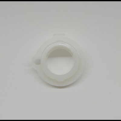 Anel plástico branco com salientes numa superfície branca