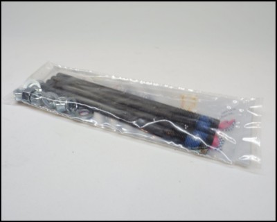 Molhos pretos com pontas vermelhas e azuis em saco plástico transparente sobre superfície branca.