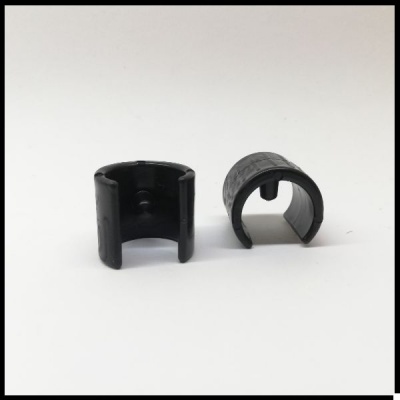 Dois componentes cilíndricos pretos em plástico sobre fundo branco