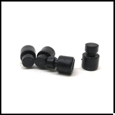 Cinco pesos negros cilíndricos pequenos sobre superfície branca