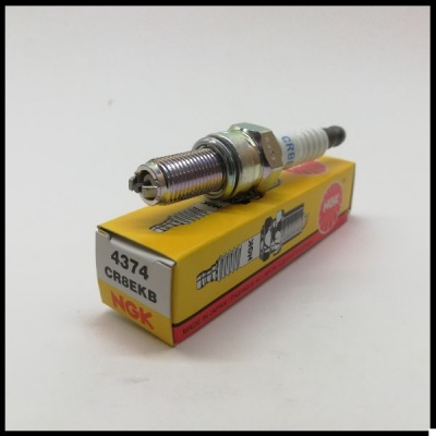 Vela de ignição NGK CR8EKB em cima da caixa amarela