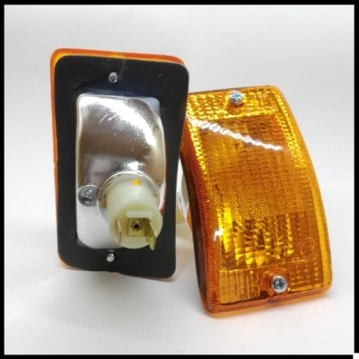 Duas luzes amarelas retangulares com moldura preta e parafusos em fundo branco