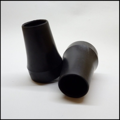 Dois protetores de borracha pretos cónicos numa superfície branca.