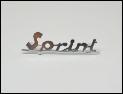Peça decorativa em aço cromado com a palavra 'Sprint' em letras cursivas