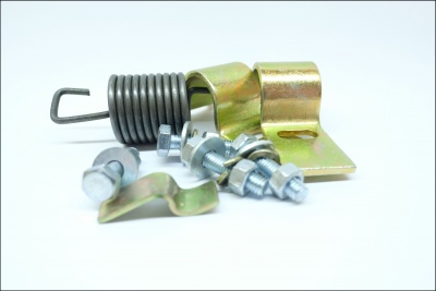 Mola e parafusos metálicos dourados em fundo branco