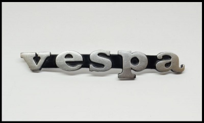 Emblema metálico com a palavra vespa