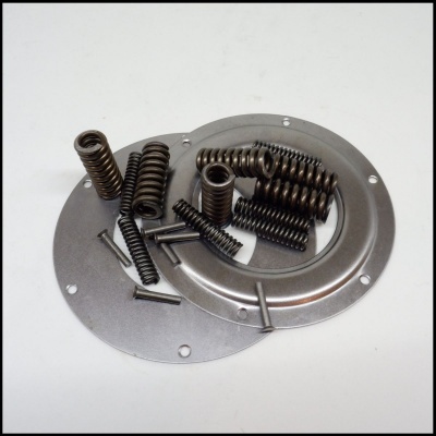 Placas metálicas circulares prateadas com molas e pinos sobre superfície branca