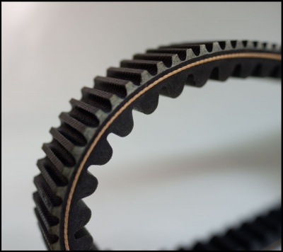 Correia dentada preta de borracha com textura rugosa e camada castanha interior